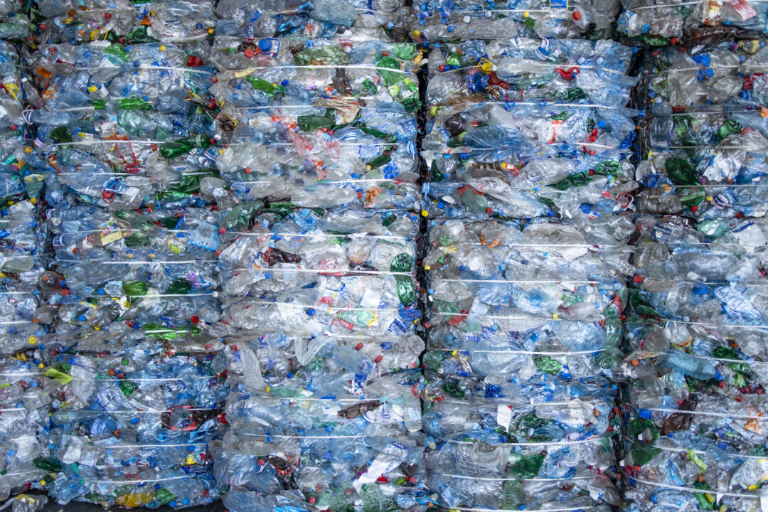 Large pile of plastic PET bottles compressed and ready for recycling.